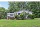 Exterior view showcases the charming white home with a cozy deck and well-maintained landscaping at 2640 S Silcox Rd, Paragon, IN 46166
