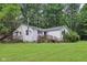 View of the home's exterior with a deck overlooking a lush green yard surrounded by mature trees at 2640 S Silcox Rd, Paragon, IN 46166