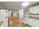 Bright kitchen with white cabinets and wood floors, adjoined to the living space at 2640 S Silcox Rd, Paragon, IN 46166