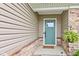 Charming covered entry featuring a modern sage green door and lush greenery at 2747 Stonebridge Dr, Lebanon, IN 46052