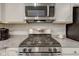 Close-up of stainless steel gas range and microwave showcasing granite countertops and modern appliances at 2747 Stonebridge Dr, Lebanon, IN 46052