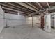 Unfinished basement space with exposed brick, utility connections, and concrete floor, offering potential for customization at 2945 N Denny St, Indianapolis, IN 46218