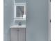 Modern bathroom featuring a new vanity with an illuminated mirror, stylish gray cabinets, and fresh paint at 2945 N Denny St, Indianapolis, IN 46218