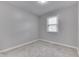 Neutral bedroom showcasing natural light from a single window and carpeted floors at 2945 N Denny St, Indianapolis, IN 46218