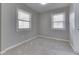 Cozy bedroom with plush gray carpet, fresh paint, and abundant natural light from two windows at 2945 N Denny St, Indianapolis, IN 46218