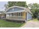 Charming home featuring a welcoming front porch with a bright yellow door and lush front lawn at 2945 N Denny St, Indianapolis, IN 46218