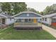 Charming home featuring a welcoming front porch with a bright yellow door and a well-maintained lawn at 2945 N Denny St, Indianapolis, IN 46218