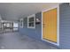 Inviting front porch featuring a bright yellow front door, freshly painted siding, and a modern wall sconce at 2945 N Denny St, Indianapolis, IN 46218