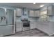 Modern kitchen with stainless steel appliances, granite countertops, gray cabinets, and new flooring at 2945 N Denny St, Indianapolis, IN 46218