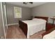 Cozy bedroom featuring wood furnishings, soft carpet, and a bright window with natural light at 305 N Warman Ave, Indianapolis, IN 46222