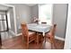 Inviting dining room with wood floors, a four-chair table setting, and natural light from the window at 305 N Warman Ave, Indianapolis, IN 46222