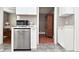 Bright kitchen with stainless steel dishwasher and a view to the dining room at 305 N Warman Ave, Indianapolis, IN 46222