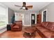 Comfortable living room featuring hardwood floors, leather furniture, and a view to the entryway at 305 N Warman Ave, Indianapolis, IN 46222