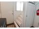 Stairwell featuring painted white walls, a white door, and a small window with blinds at 305 N Warman Ave, Indianapolis, IN 46222