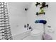 Clean bathroom boasts a shower with tub, white tiled walls, modern fixtures, and open shelving for storage at 3141 Citadel Ct, Indianapolis, IN 46268