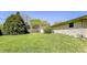 Spacious, grassy backyard with a wooden fence and mature trees for privacy at 3215 E 10Th St, Anderson, IN 46012