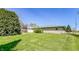 Expansive grassy backyard with mature trees and a brick home exterior at 3215 E 10Th St, Anderson, IN 46012