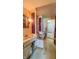 Bathroom with a tub/shower combo featuring a pink curtain and adjacent toilet and sinks with purple accents and vintage wallpaper at 3215 E 10Th St, Anderson, IN 46012