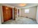 A bedroom with an adjacent view of a bathroom and closet with exposed shelving at 3215 E 10Th St, Anderson, IN 46012