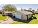 Side view of a single-story brick home with an attached garage and well-kept lawn at 3215 E 10Th St, Anderson, IN 46012
