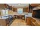 Kitchen features a double sink, stove, and dark stained wood cabinetry at 3215 E 10Th St, Anderson, IN 46012