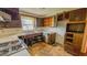Kitchen features a double sink, stove, and wooden cabinetry at 3215 E 10Th St, Anderson, IN 46012