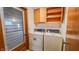 A laundry room featuring wood cabinets, a windowed door, and a washer and dryer at 3215 E 10Th St, Anderson, IN 46012