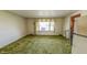 Living room with textured green carpet and window with decorative shade at 3215 E 10Th St, Anderson, IN 46012