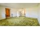 Living room with textured green carpet and view into dining area and hallway at 3215 E 10Th St, Anderson, IN 46012