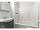 This bathroom features a white shower-tub combo, gray vanity with modern sink, and bright lighting at 3453 W 12Th St, Indianapolis, IN 46222