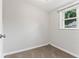 Empty room with new carpet, fresh paint, a window with backyard view, and electrical outlet at 3453 W 12Th St, Indianapolis, IN 46222