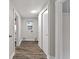 Hallway with wood-look flooring, white walls and trim, closet, access to laundry, and natural lighting at 3453 W 12Th St, Indianapolis, IN 46222