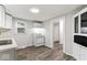 Bright kitchen features white appliances, cabinets and countertops, and updated wood-look flooring at 3453 W 12Th St, Indianapolis, IN 46222