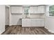 Bright kitchen features white cabinets and countertops, stainless sink, updated faucet, and new floors at 3453 W 12Th St, Indianapolis, IN 46222
