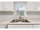 Double sink, white countertop, and updated fixtures create a clean, efficient kitchen work space at 3453 W 12Th St, Indianapolis, IN 46222