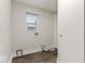 This laundry area has wood-look flooring, bright window, white walls and trim, with closet at 3453 W 12Th St, Indianapolis, IN 46222