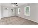 Bright living room with a ceiling fan, large windows, and plush carpeting at 3453 W 12Th St, Indianapolis, IN 46222