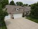 Charming single-Gathering home boasts a three-car garage, manicured lawn, and traditional brick facade at 4232 Parliament Way, Avon, IN 46123