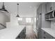 Open concept kitchen view including island with white countertop, grey cabinets, and stainless appliances at 449 Shade St, Carmel, IN 46290