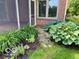 Inviting yard featuring lush garden beds with vibrant hostas and brick accents at 458 Burlington Ln, Carmel, IN 46032