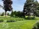 Picturesque backyard with lush lawn, mature trees, and manicured landscaping at 458 Burlington Ln, Carmel, IN 46032