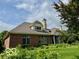 Back exterior showcasing a brick house, screened in porch, and manicured yard at 458 Burlington Ln, Carmel, IN 46032