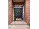 Charming front door entrance with brick surround, accent topiary, and a wreath on the door at 458 Burlington Ln, Carmel, IN 46032