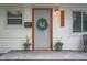 Close-up of the front door with a decorative wreath, potted plants, and a welcoming ambiance at 4747 Wellington Ave, Lawrence, IN 46226