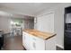 Modern kitchen island with butcher block countertop, white cabinetry, open to dining area at 4747 Wellington Ave, Lawrence, IN 46226
