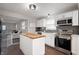 Modern kitchen with stainless steel appliances, white cabinetry, tile backsplash, and a butcher block island at 4747 Wellington Ave, Lawrence, IN 46226
