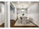 Dining room featuring hardwood floors, wainscoting, a modern chandelier, and neutral decor at 478 Firefly Ln, Carmel, IN 46032