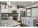 Open kitchen with granite counters, stainless steel appliances, and gray island at 478 Firefly Ln, Carmel, IN 46032