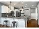 Kitchen island with bar stools, granite countertops, pendant lights, and stainless steel appliances at 478 Firefly Ln, Carmel, IN 46032
