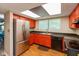 Well-lit kitchen featuring stainless steel appliances, bright orange cabinets, and a practical layout, with open view at 4965 Hawthorne Way, Avon, IN 46123